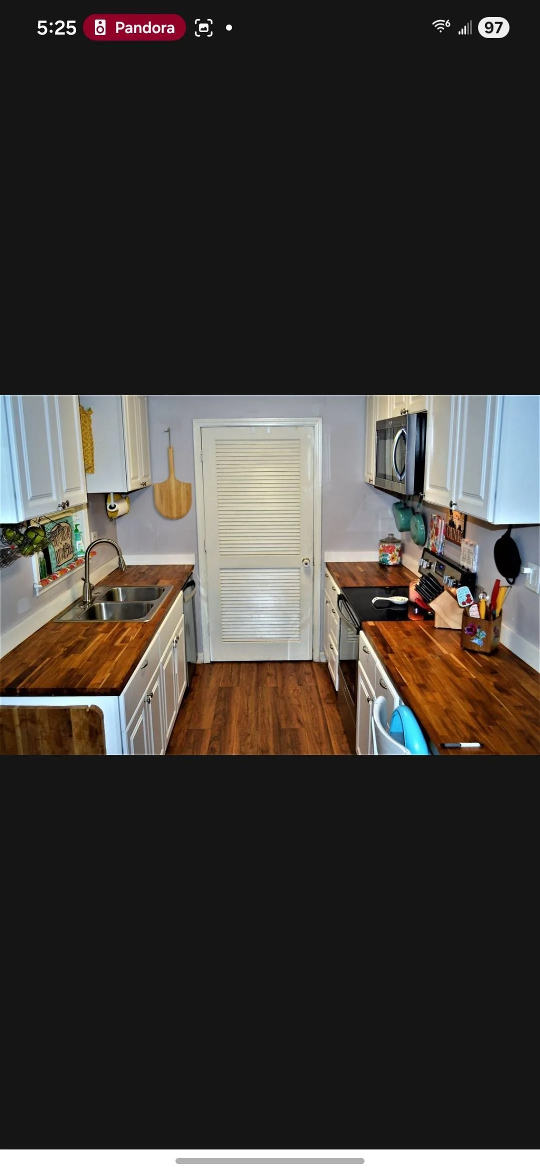 Wood countertops installed in white kitchen with stainless steel sink and cabinetry