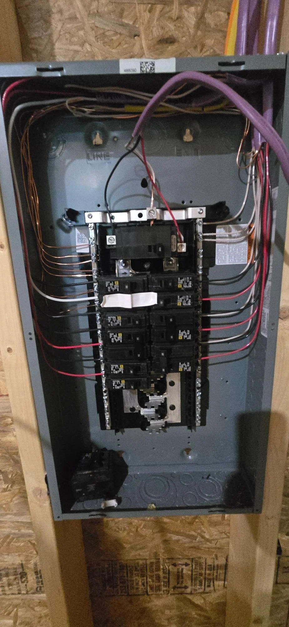 Electrical panel with 200-amp service, circuit breakers, and organized copper wire connections