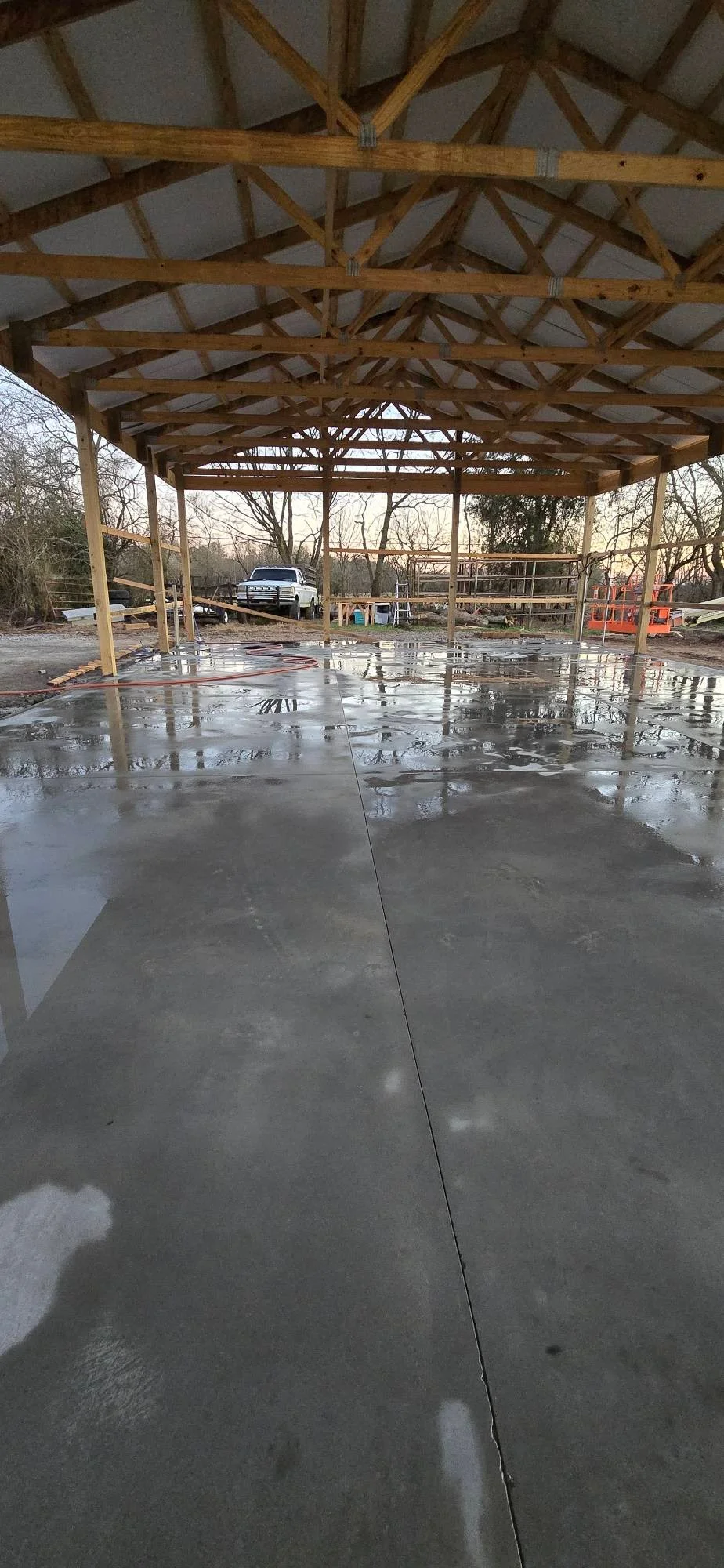 Finished concrete pad with control joints under timber frame structure with exposed beams