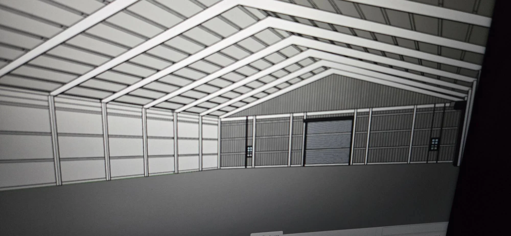 Interior view of metal frame building with white steel beams, corrugated metal roof and walls, overhead doors