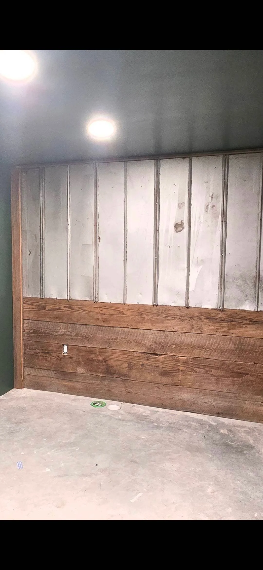 Vertical metal studs with white drywall and horizontal wood framing on interior wall